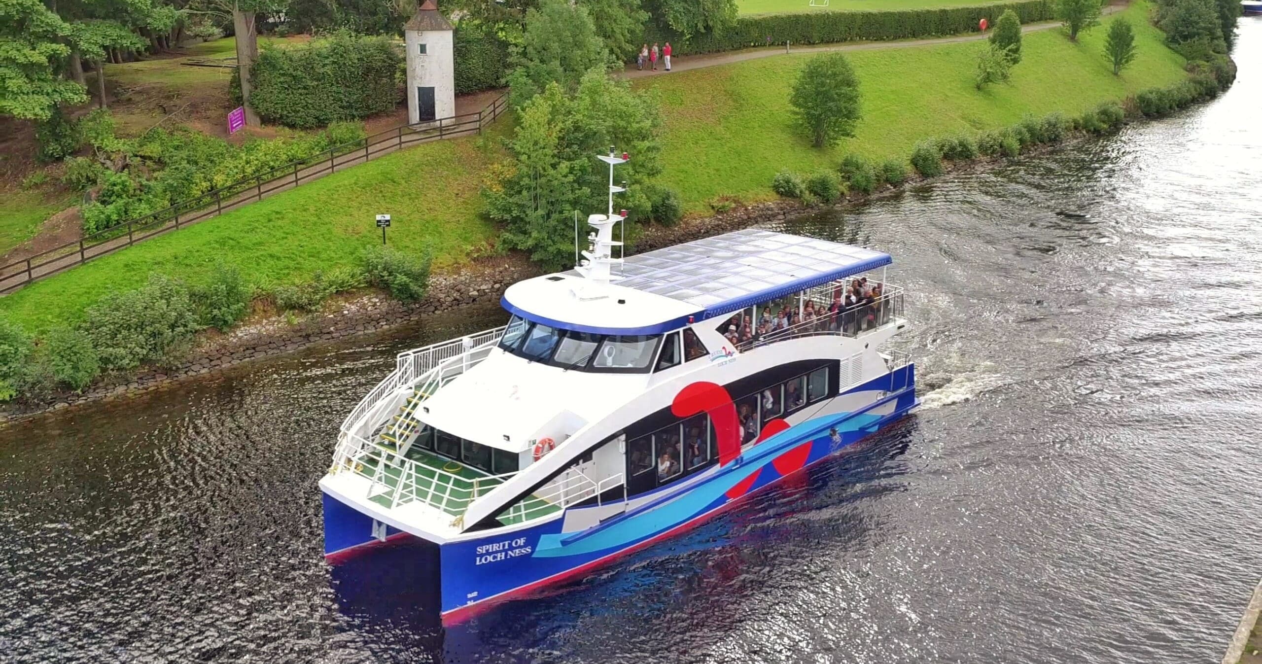 Sightseeing catamaran cruising a Scottish river canal tour