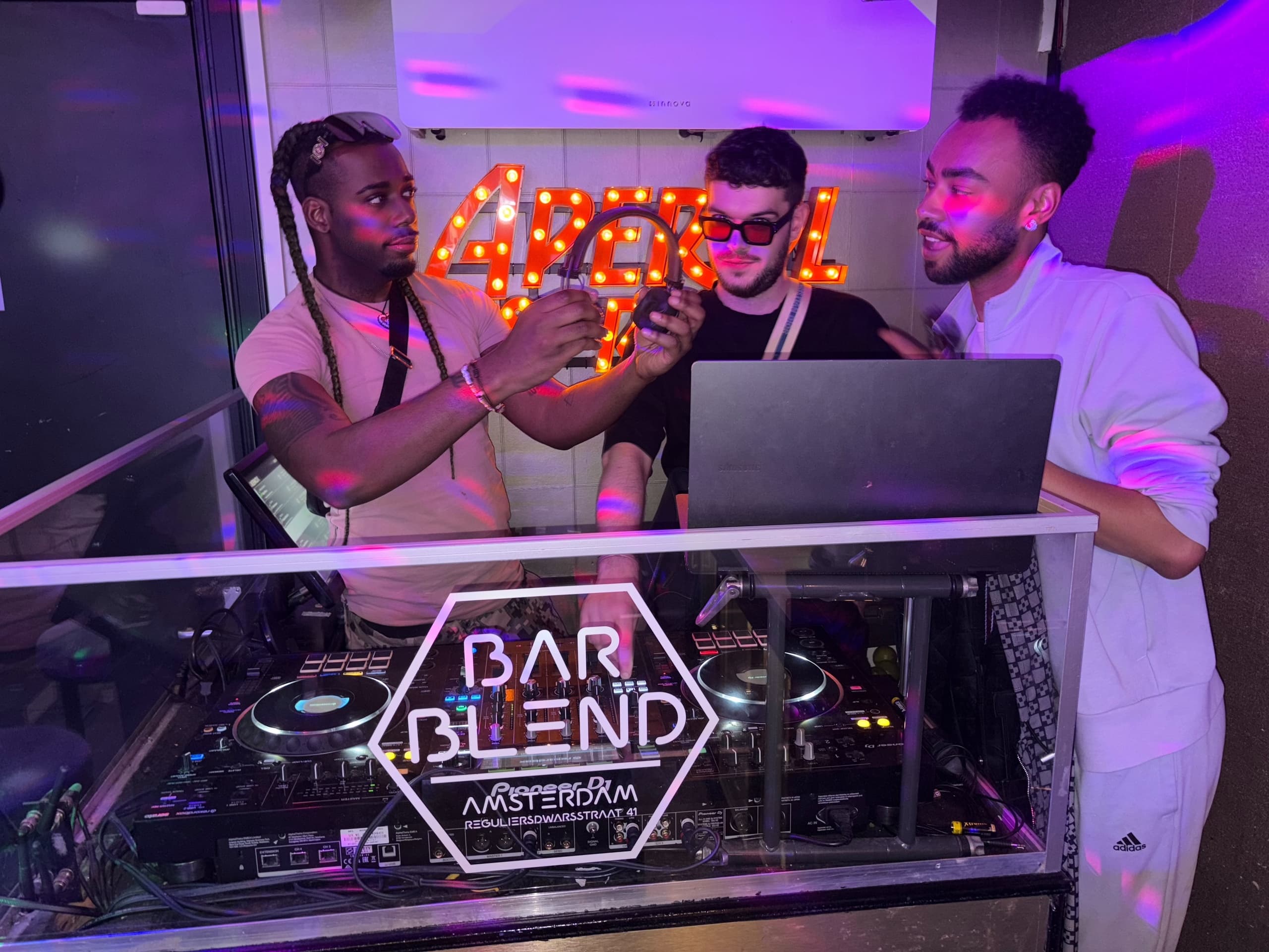 DJs performing at neon-lit Bar Blend booth, lively club night