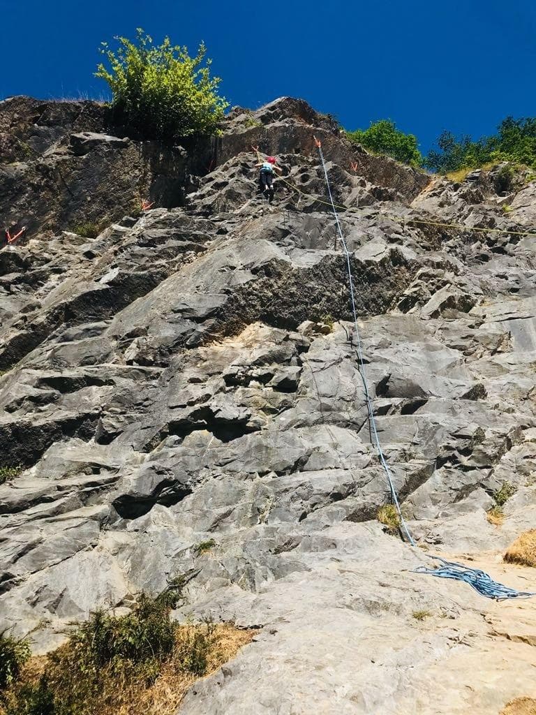 High-angle rock face showing anchored ropes for outdoor climbing