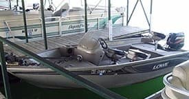 Aluminum bass fishing boat moored in covered marina, freshwater