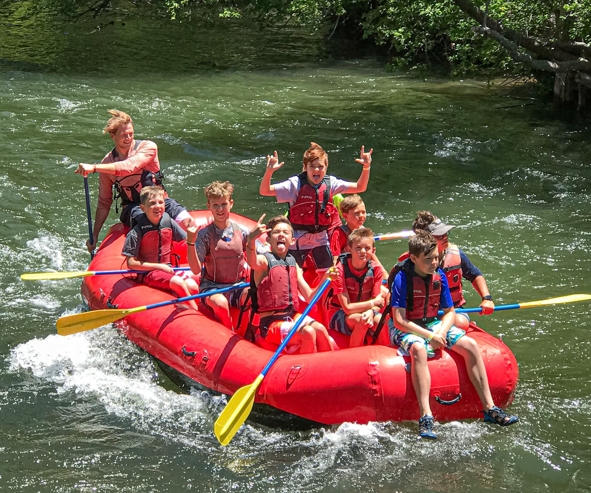 Whitewater rafting on scenic river with smiling rafters