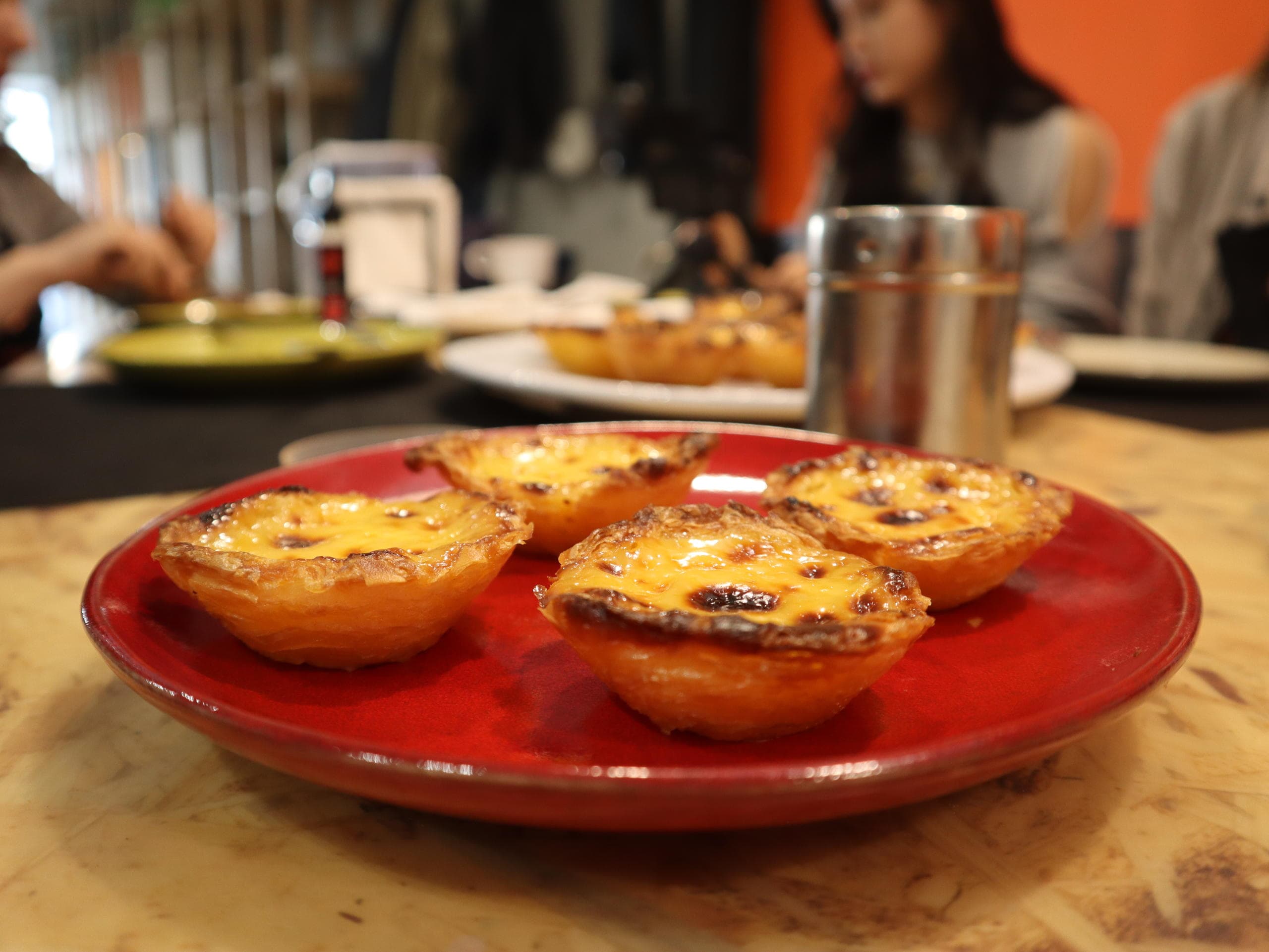 Custard tarts on red plate at indoor pastry cooking class