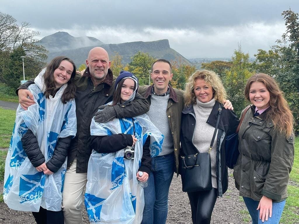 Tour group in rain ponchos with Arthur's Seat hills, Edinburgh