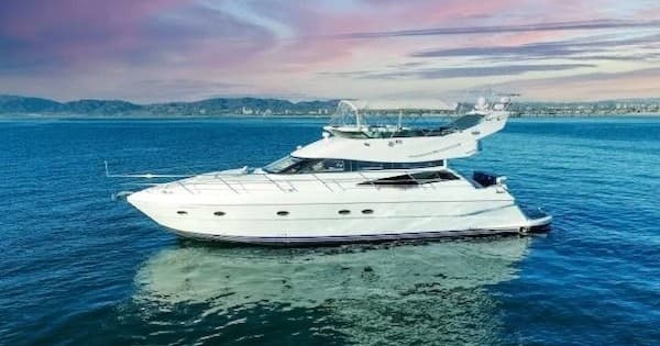 Sleek yacht sailing near coastline with dramatic blue waterscape