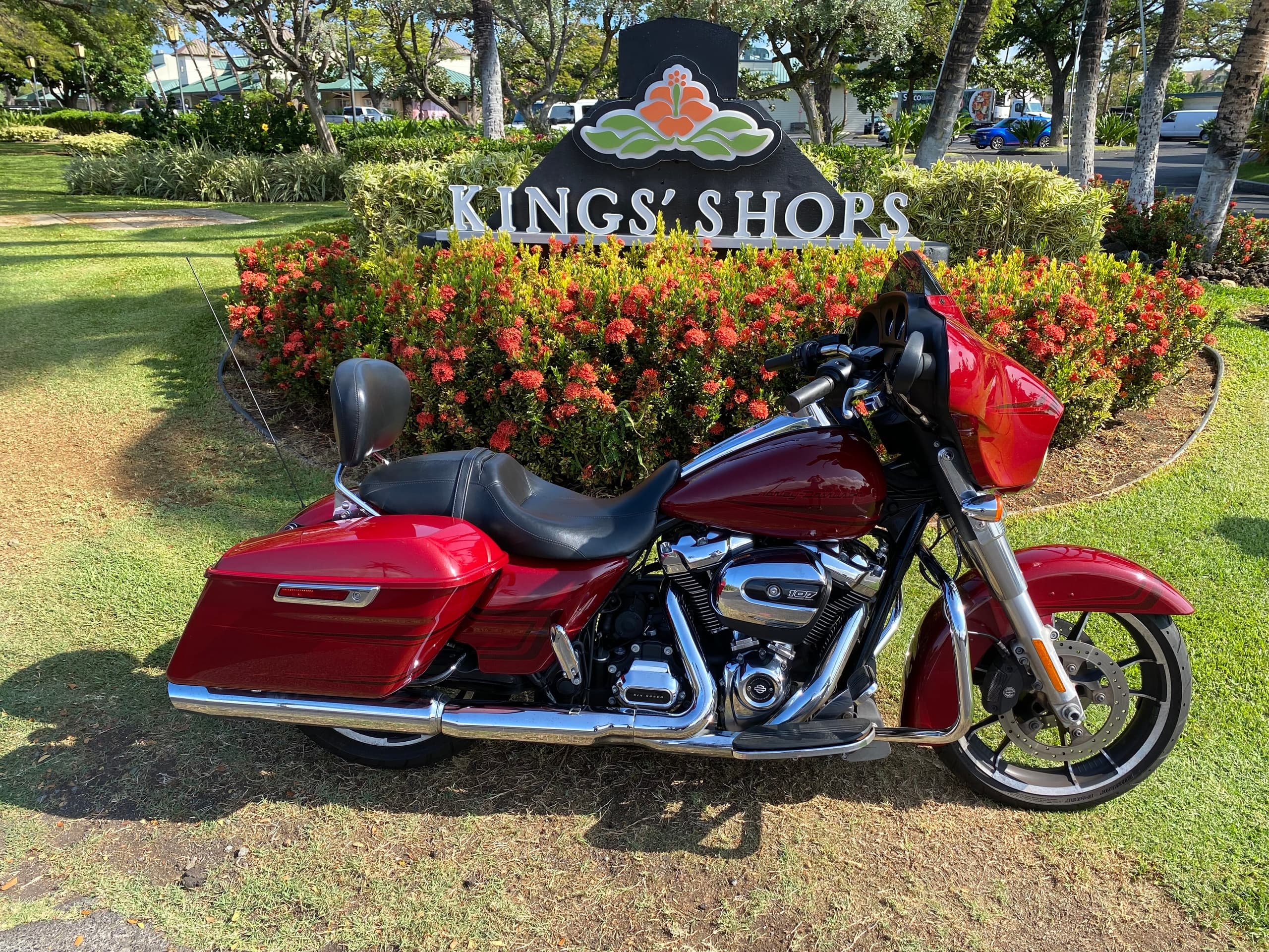 Red cruiser motorcycle parked on grass at Kings' Shops Waikoloa