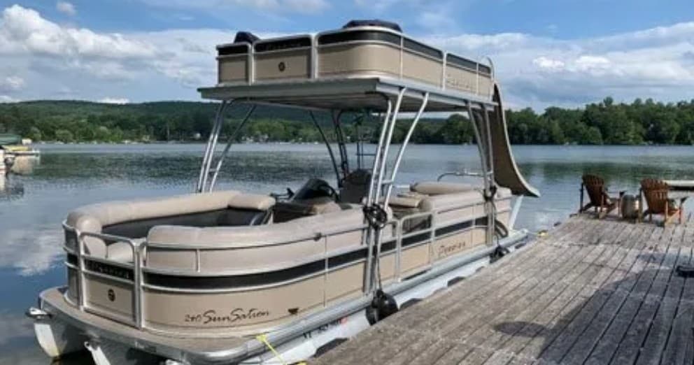 Two-level pontoon with waterslide docked on calm lakeside