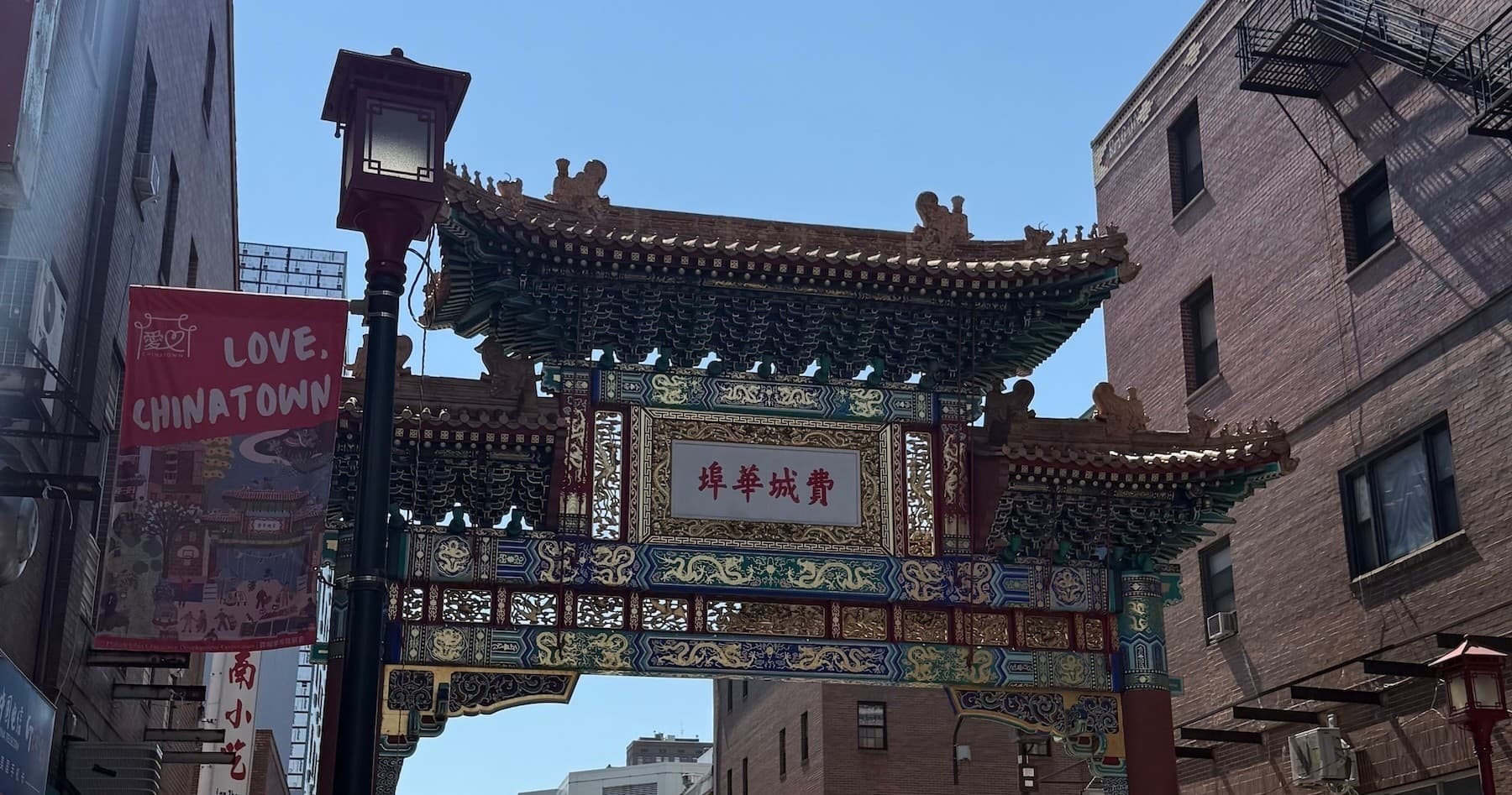 Pedestrians on guided walking tour at Chinatown gate