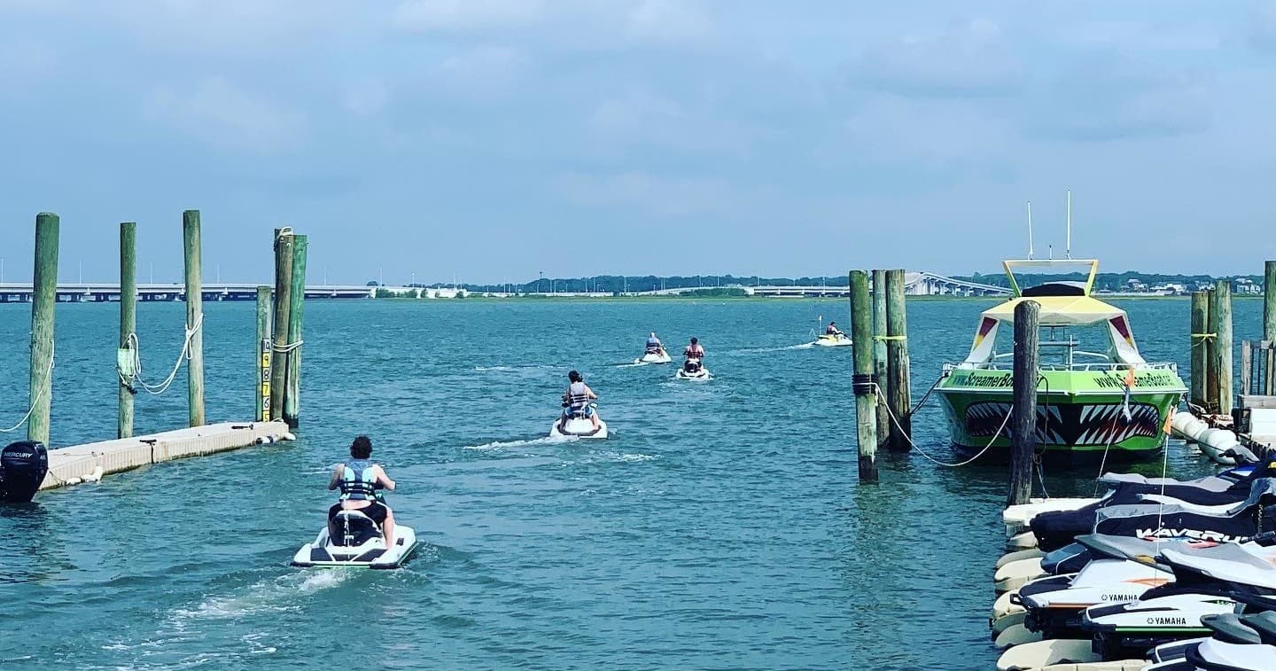 Jet ski riders navigating coastal marina waters on guided tour
