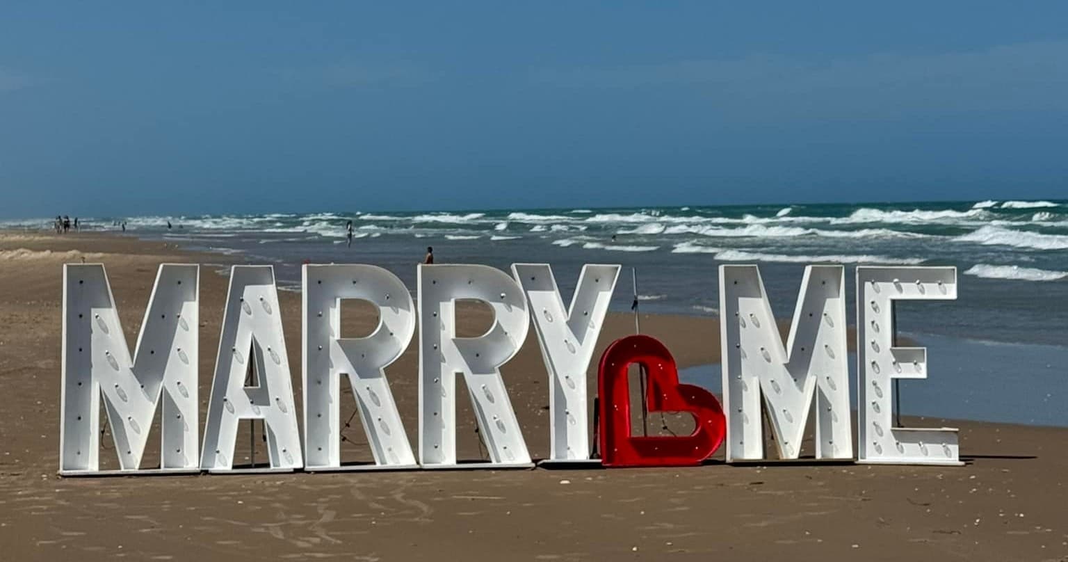 Helicopter Proposal Over South Padre Island: Pop the Question with the MARRY ME Beach Letters