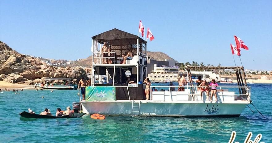 Tour boat with sunbathers offshore under clear blue sky