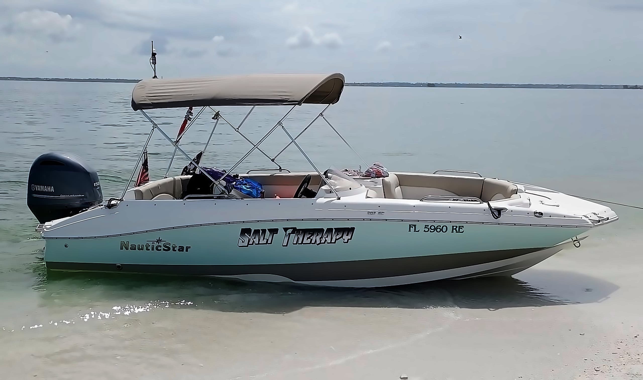 Charter boat beached on shallow sand, calm coastal waters