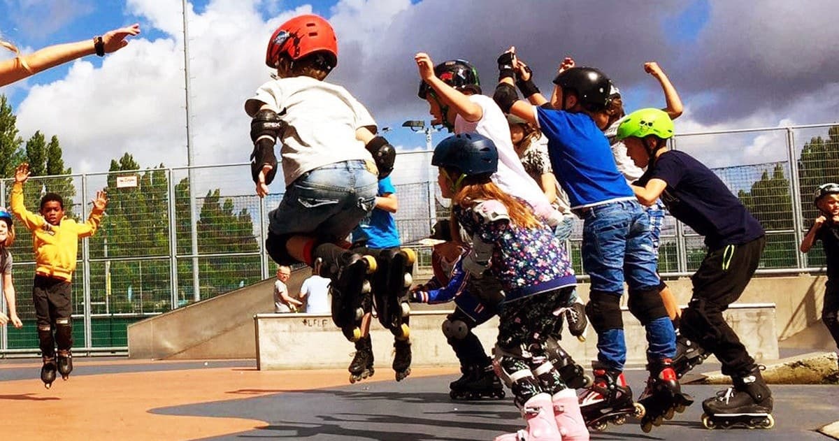 Kids rollerblading and jumping at outdoor skatepark session