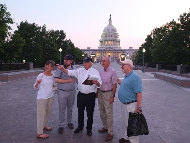 Group walking tour in front of US Capitol at dusk