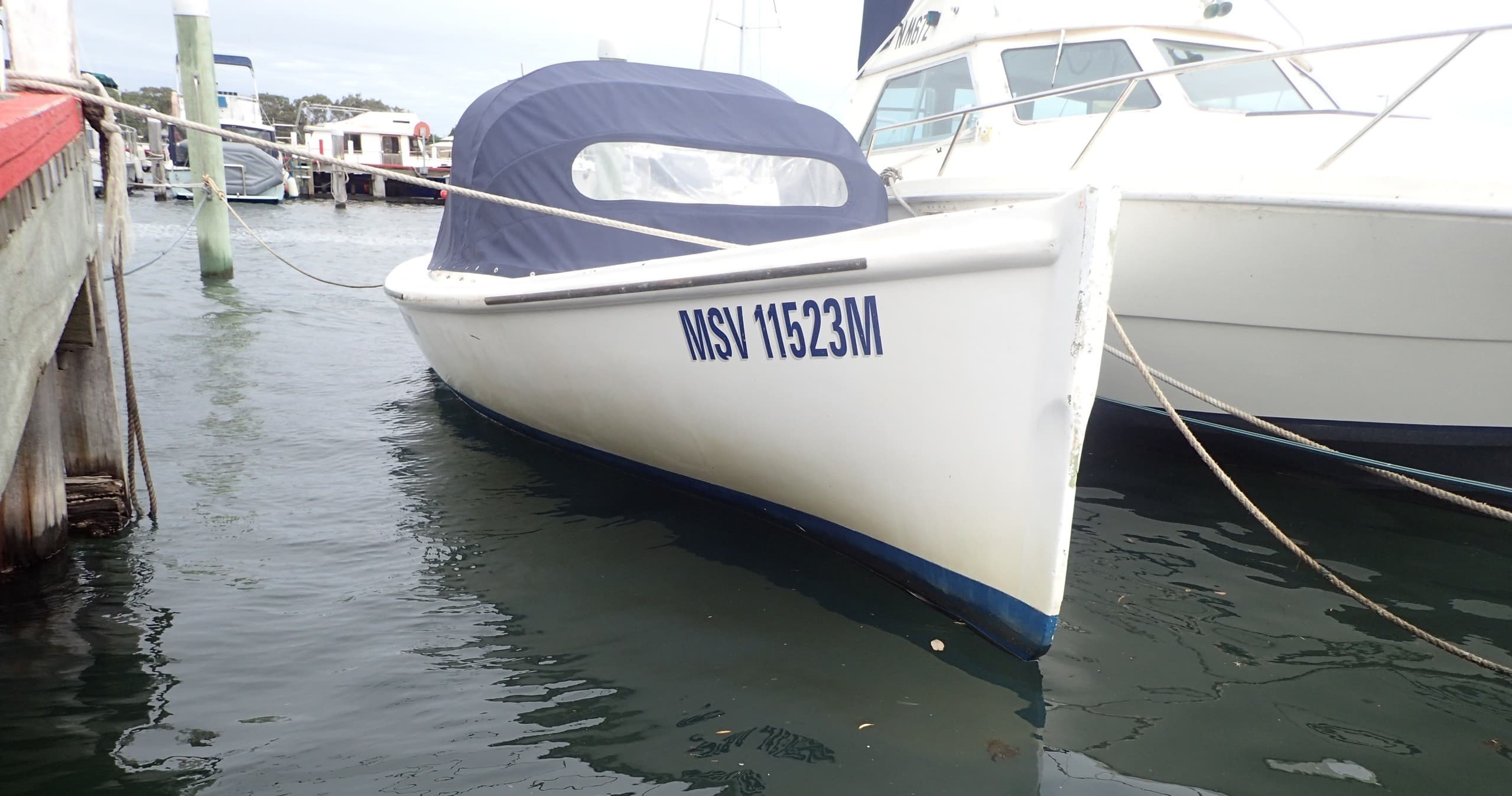 Bow of white cruiser docked at marina for nearshore boat tour