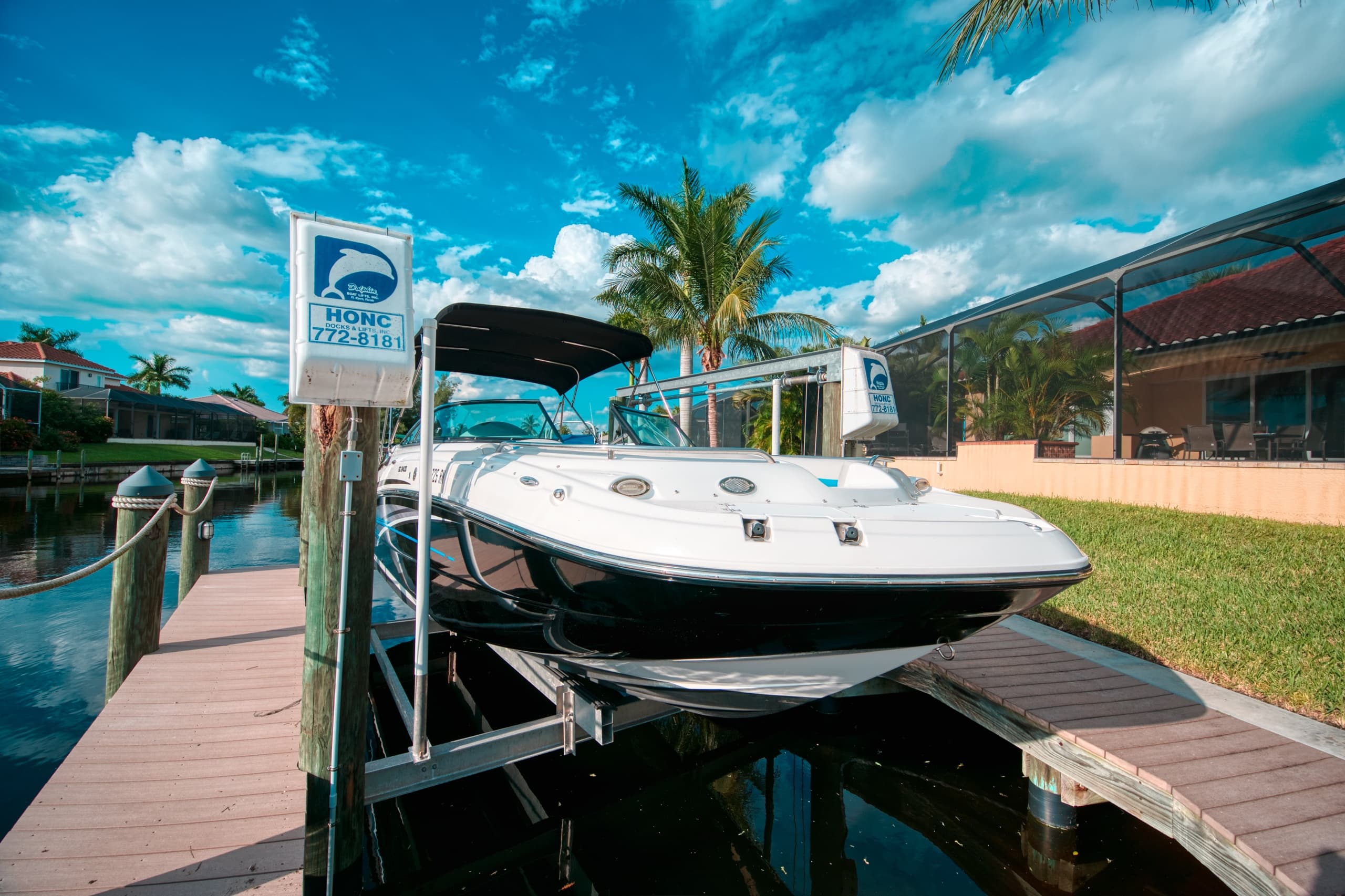Sunlit motorboat lifted on dock in tropical Florida canal, marina