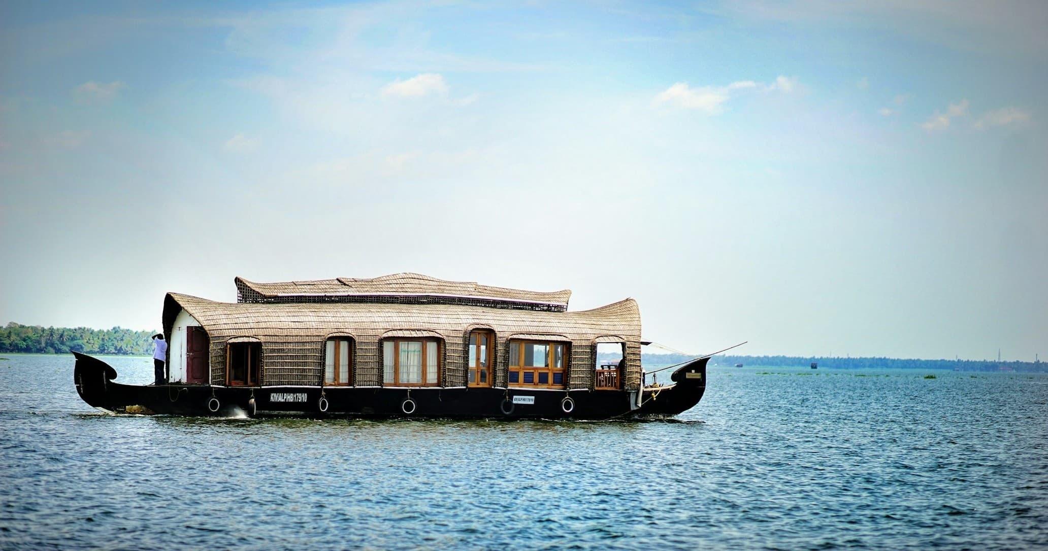 Traditional houseboat cruising calm riverfront for overnight stay