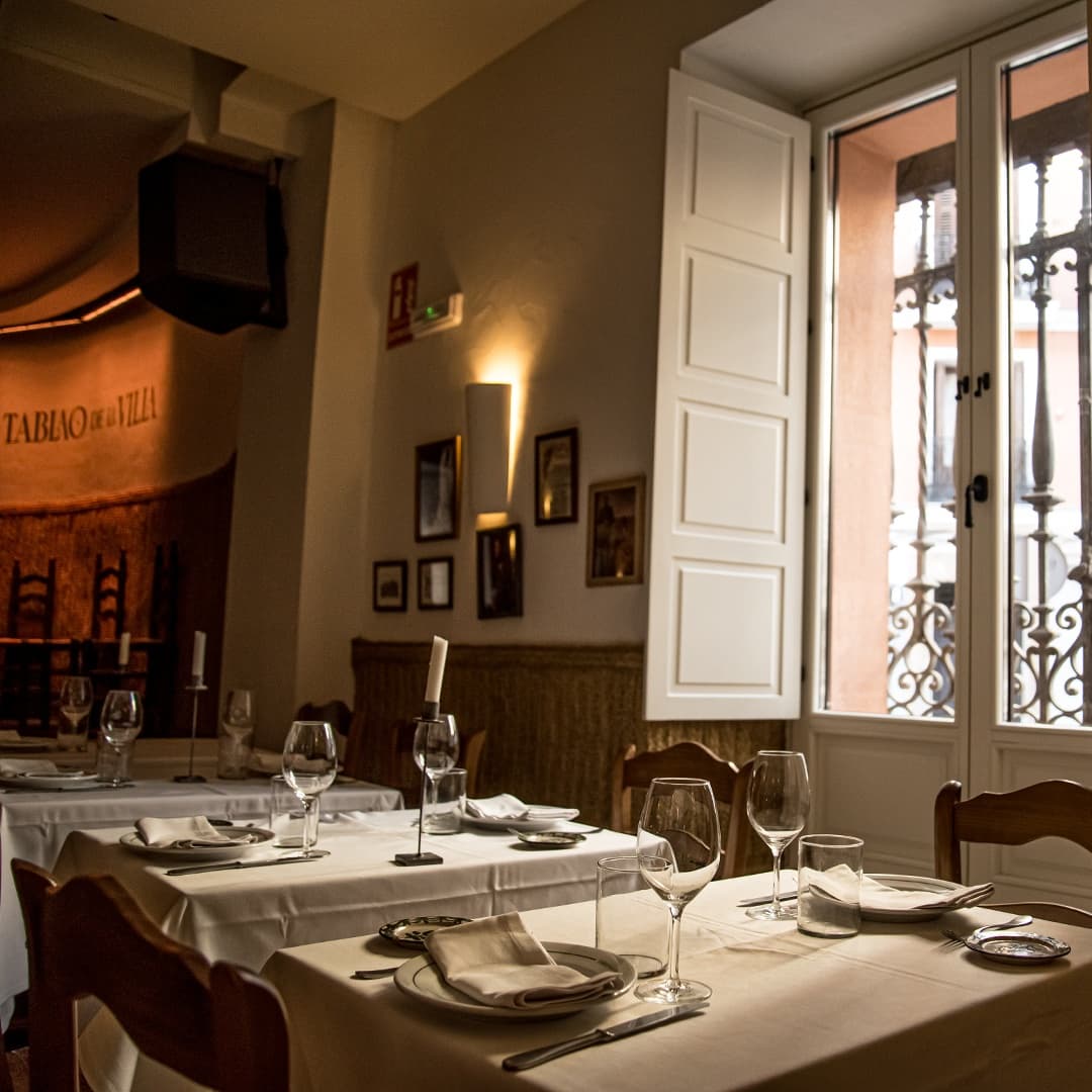 Restaurant dining tables by window in intimate tablao venue