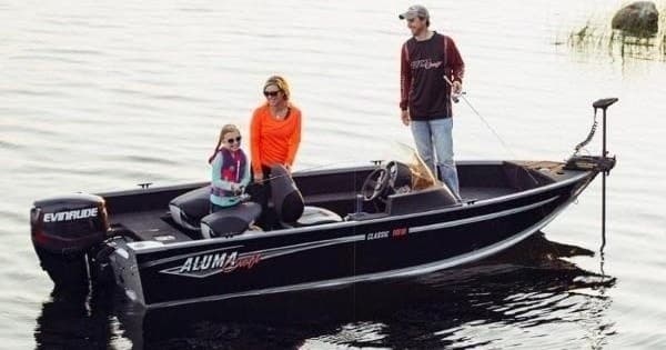 Small fishing boat with family angling on calm lake waters