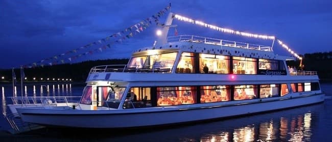 Evening river cruise boat lit up docked on calm waters