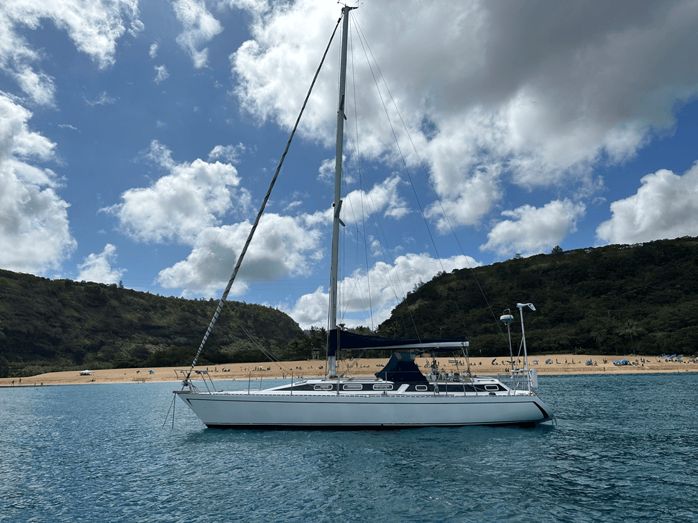 Sailboat moored in a sheltered bay beneath blue sky for cruising