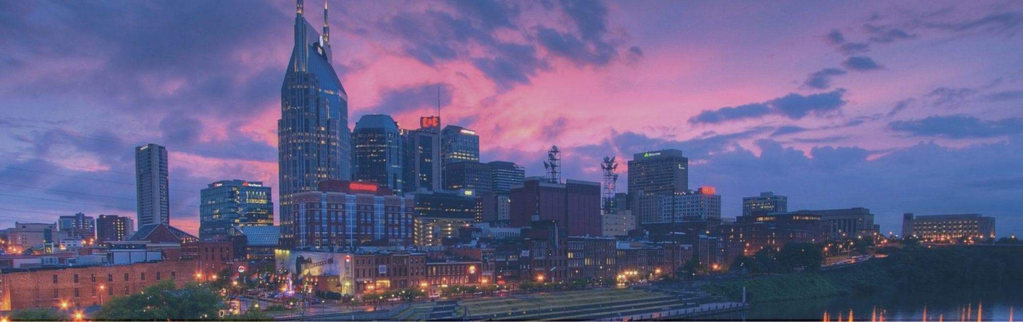 Sunset skyline of Nashville riverfront with dramatic purple sky