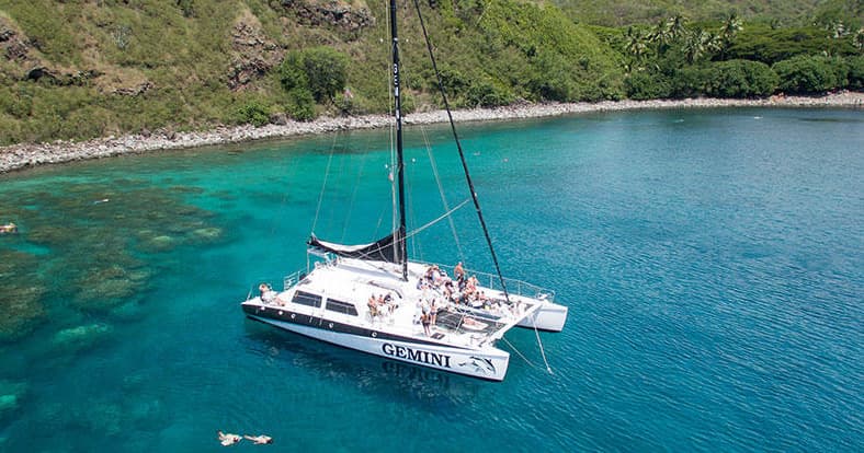 Aerial view of charter catamaran cruising clear tropical waters