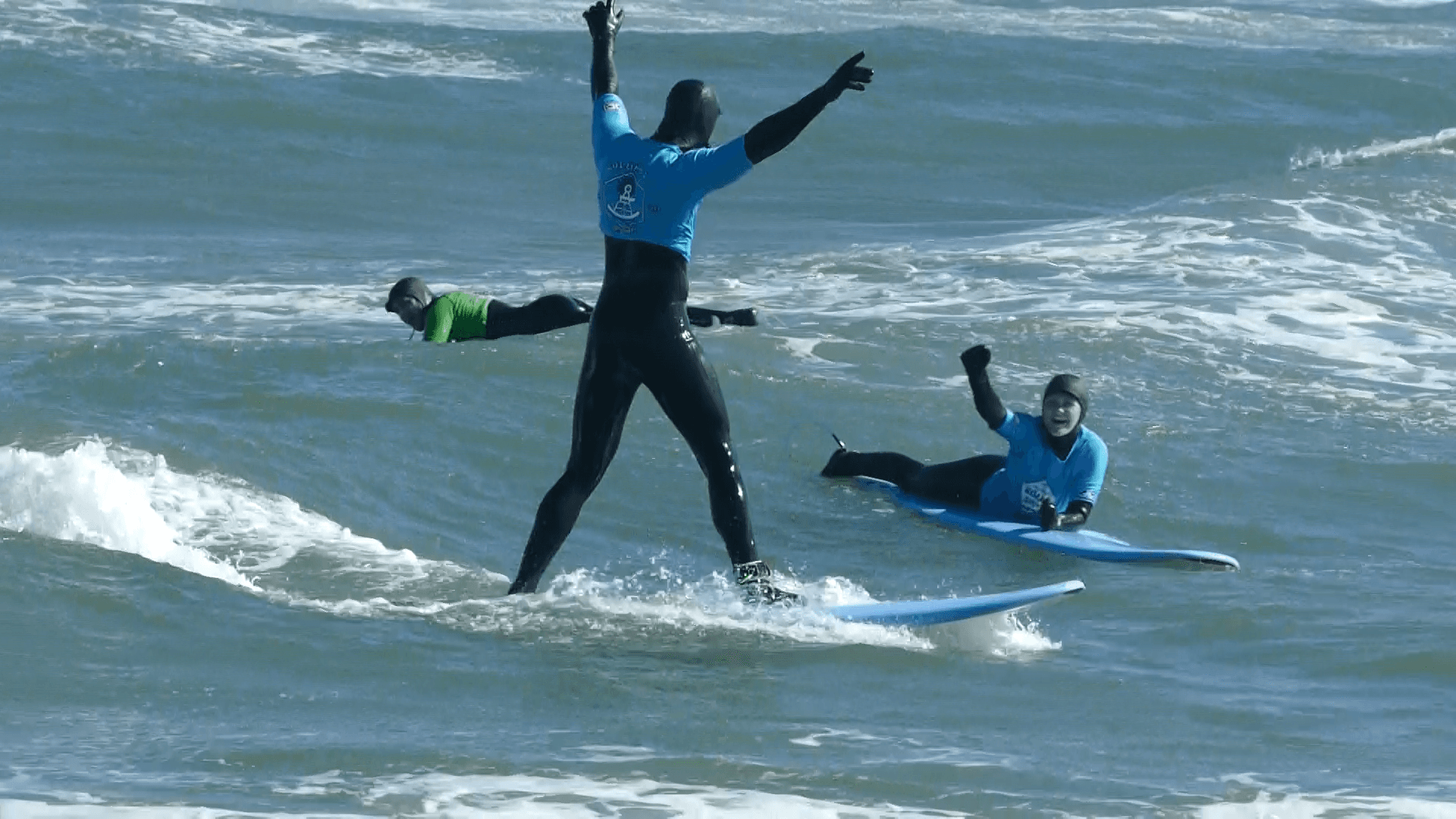 Surfer balancing on board with arms raised riding ocean wave