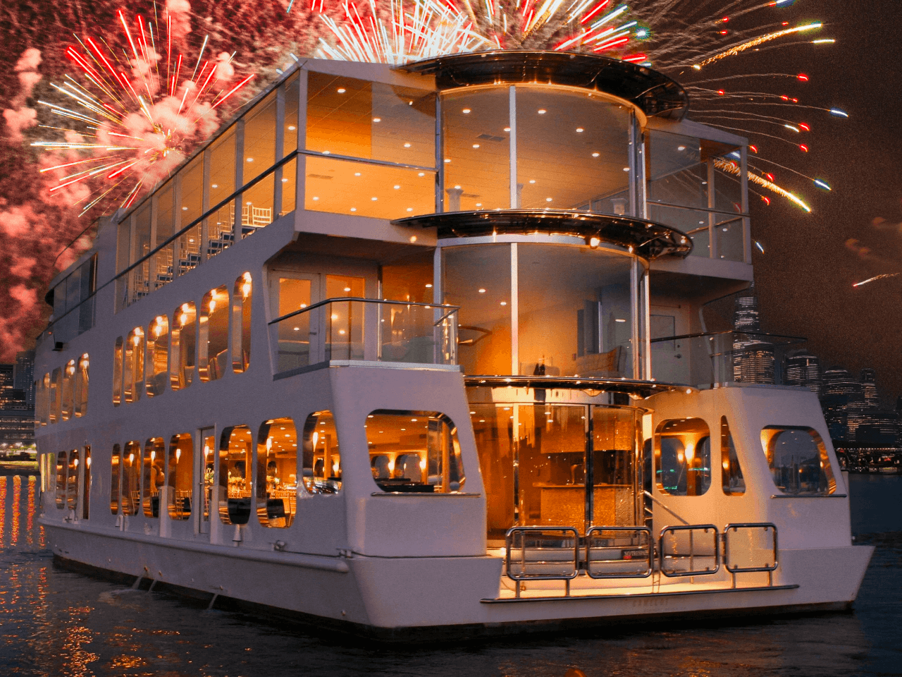 Luxury party yacht with fireworks over New York Harbor at night