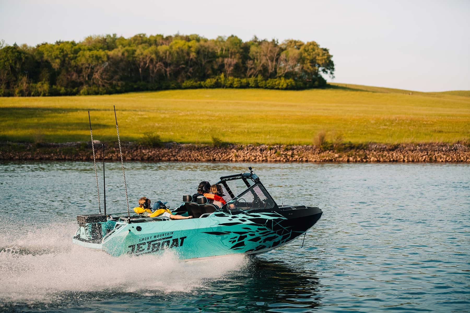 Jet boat speeding across open reservoir waters near shore