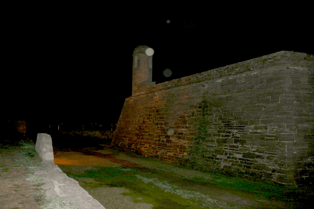 Nighttime fort wall at coastal battlement with ghost tour atmosphere