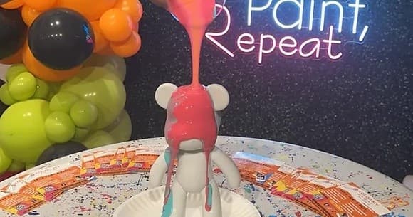 Paint-poured figurine at indoor paint studio with balloons