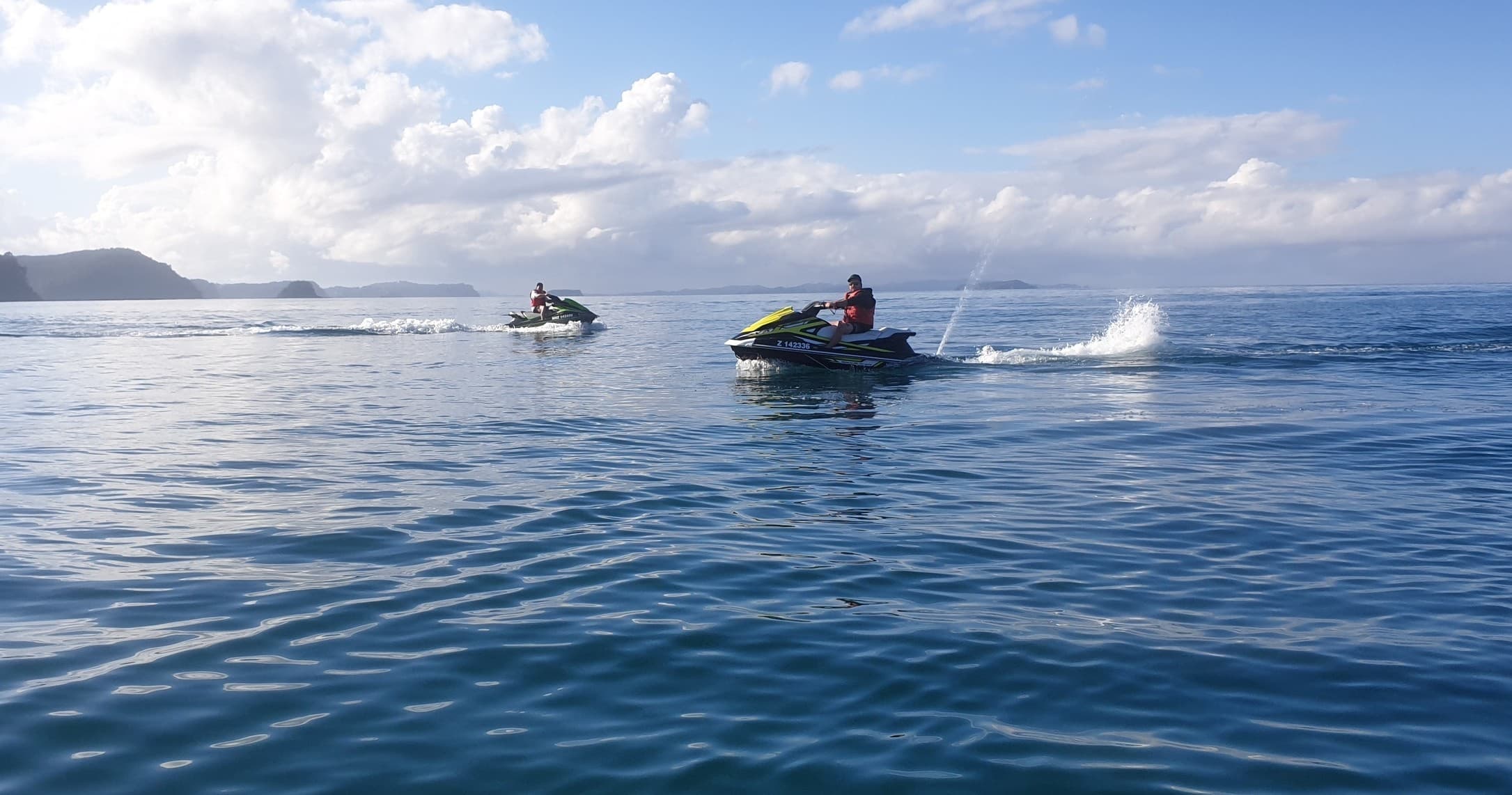 Multiple jet skis gliding across Hibiscus Coast calm bay