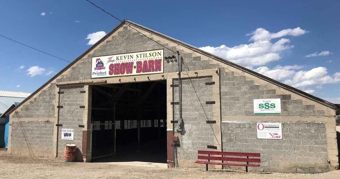 Historic show barn exterior at fairgrounds under blue sky