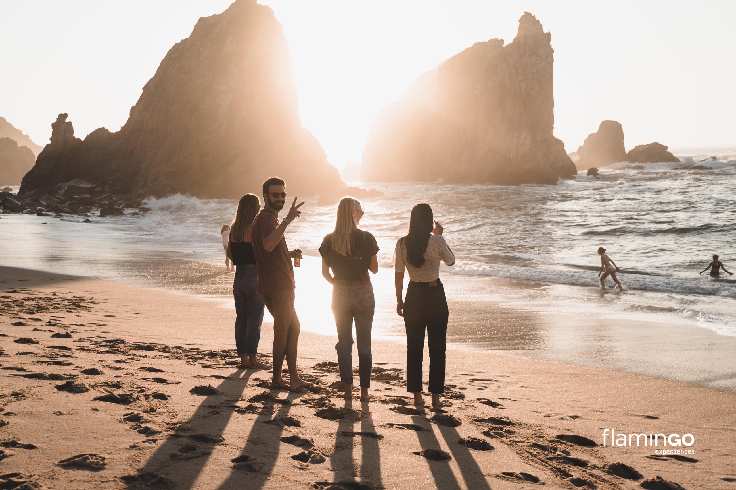 Friends on coastal beach at sunset enjoying ocean adventure