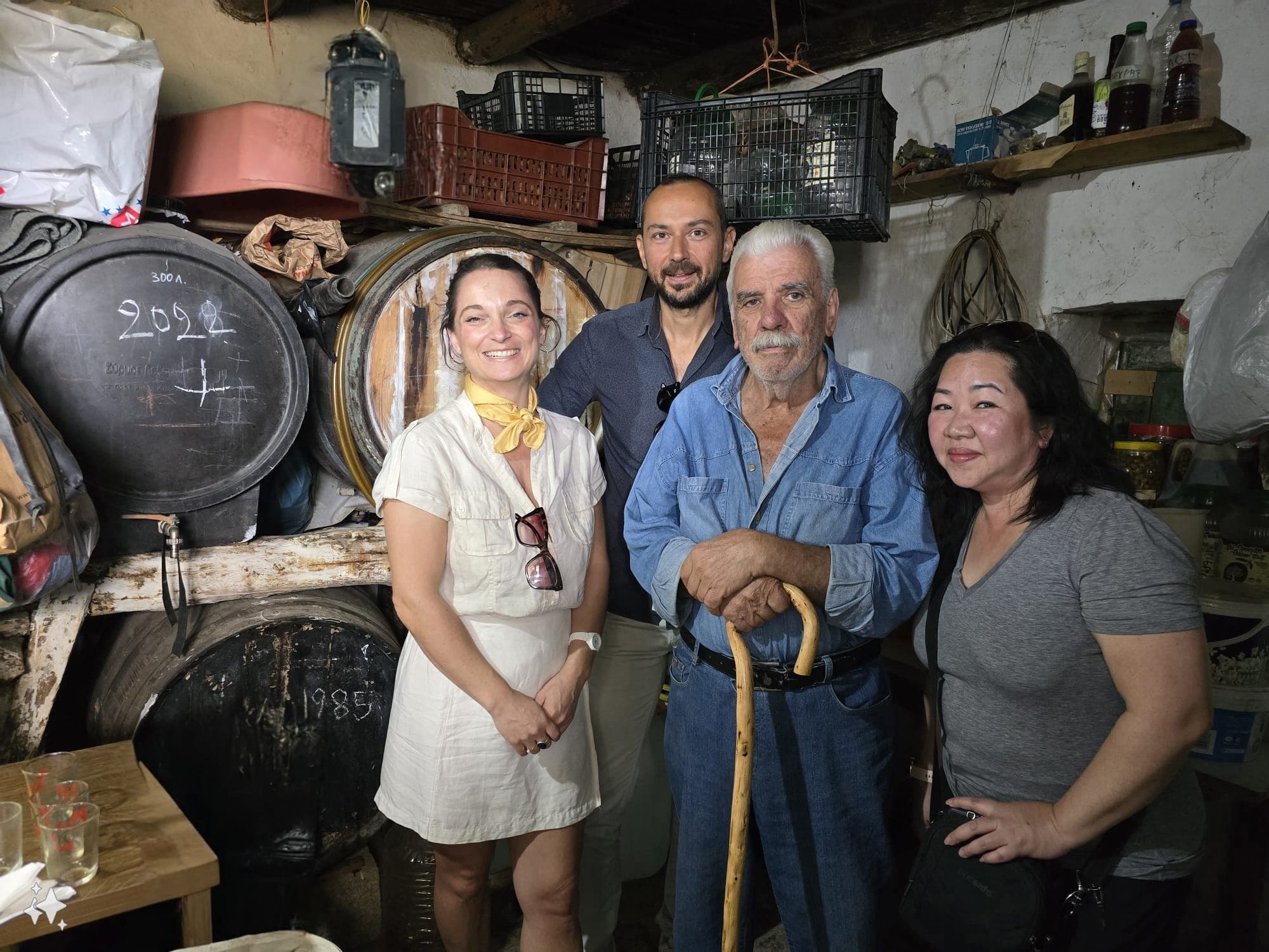 Visitors touring traditional winery cellar beside oak barrels