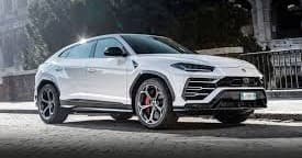 White Lamborghini Urus SUV parked on urban waterfront street scene