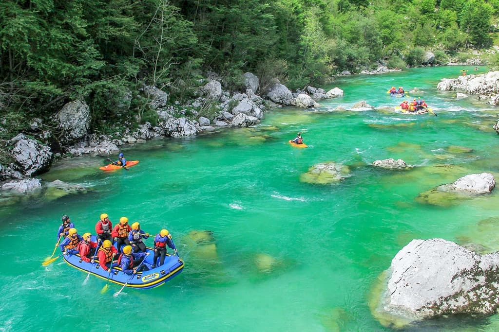 Rafting group on turquoise river through rocky green gorge