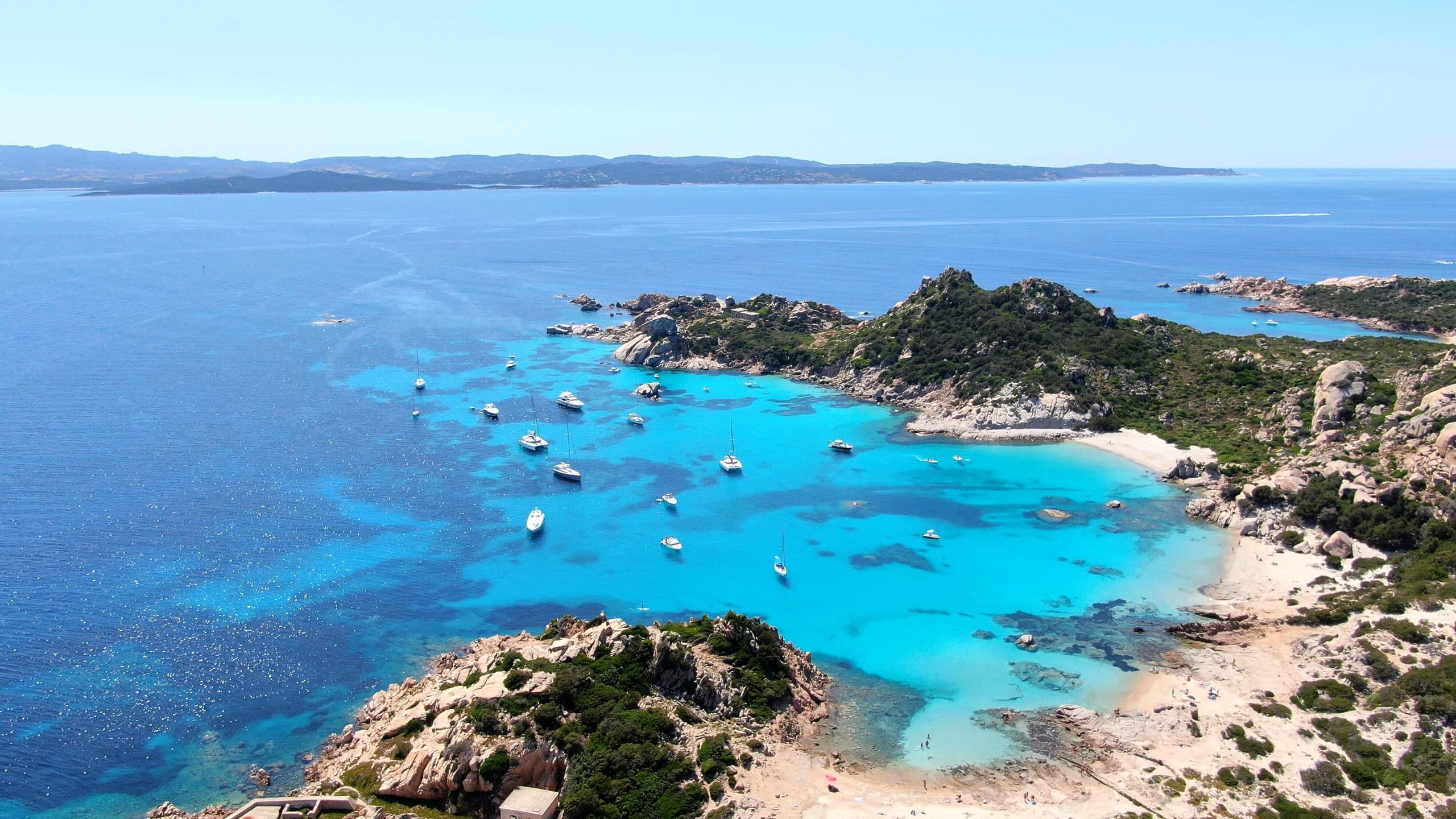 Boats anchored in turquoise island bay for snorkeling excursions