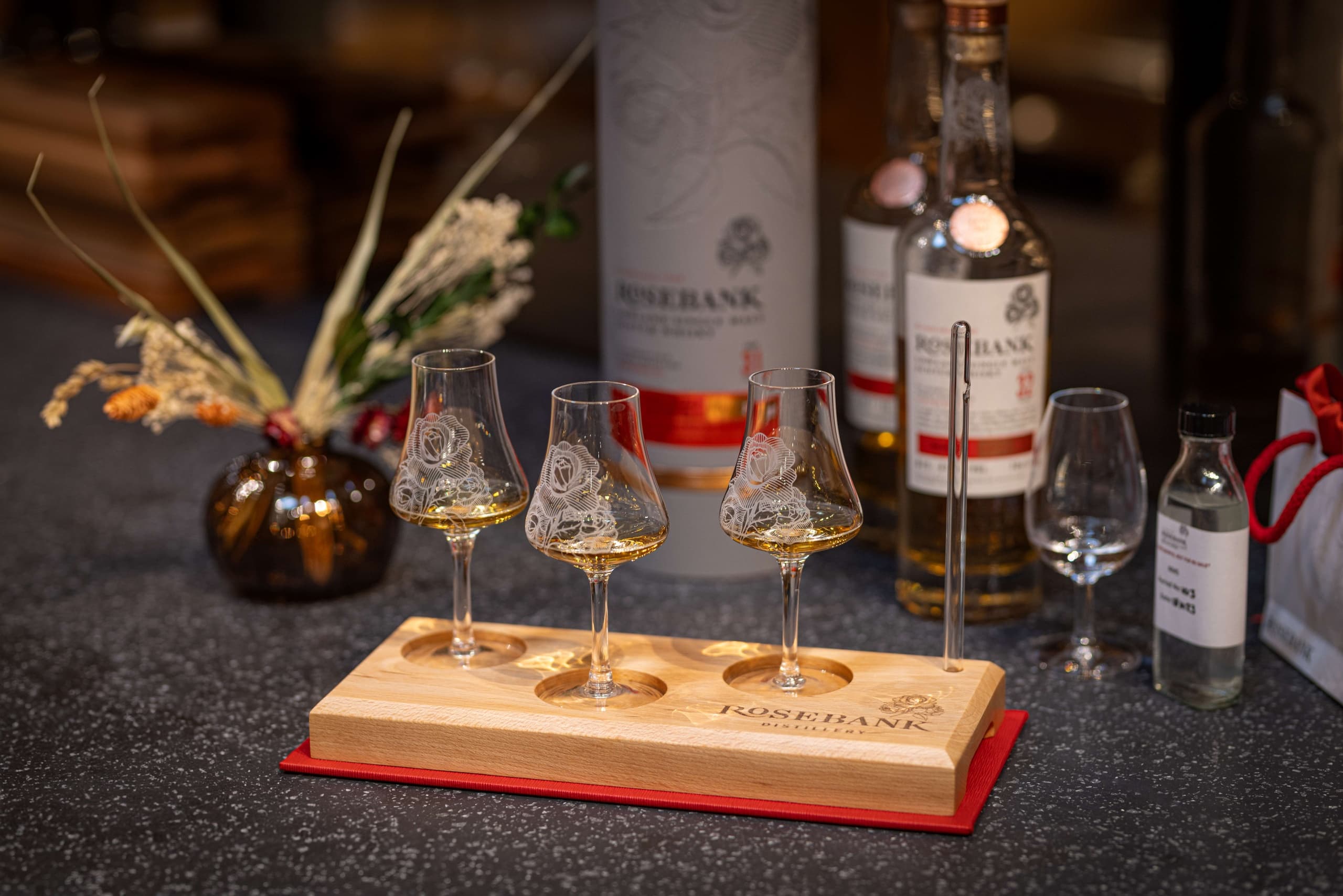 Whisky tasting flight on wooden board in Rosebank tasting room