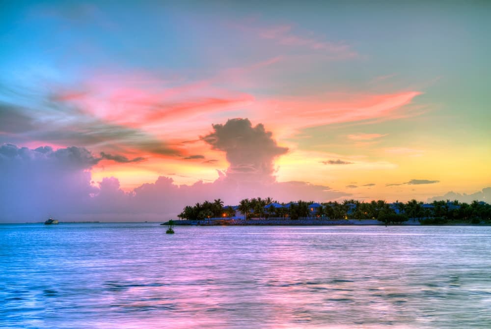 Tropical island sunset over calm waters with vibrant sky colors