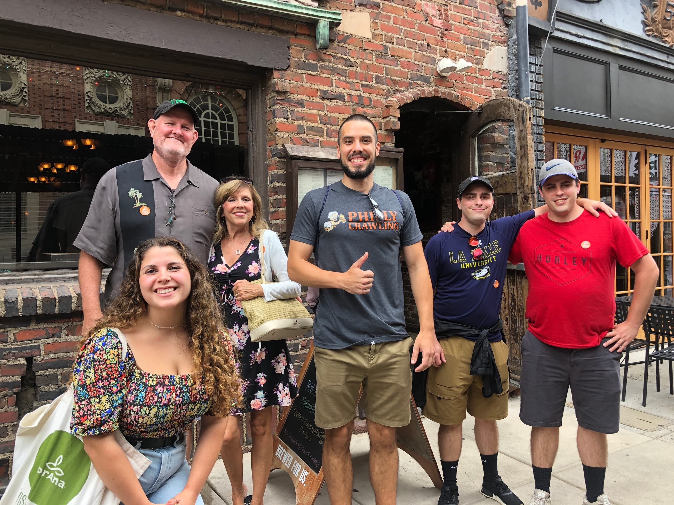 Group on Philadelphia bar crawl posing outside brick pub