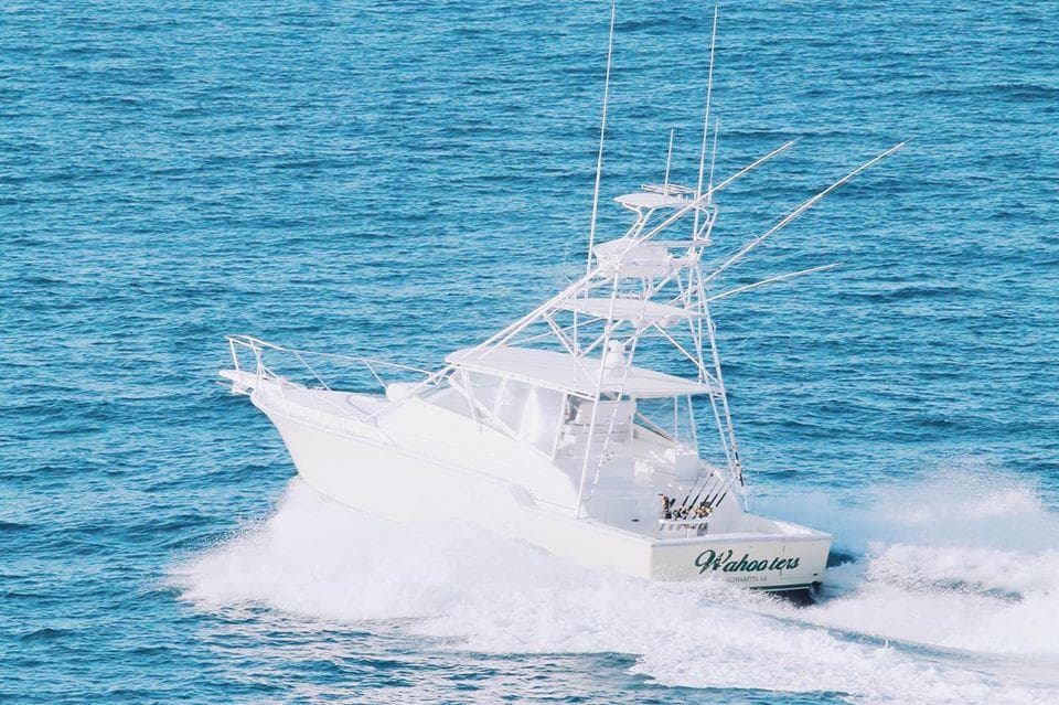 Sportfishing boat powering through ocean spray on charter