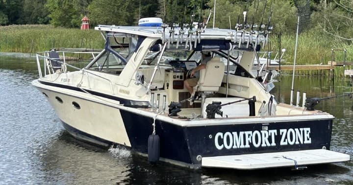 Fishing charter boat docked on calm lake, ready for anglers