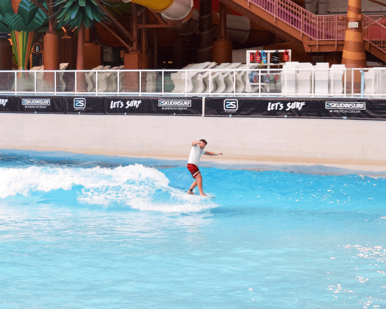 Surfer balancing on board in indoor artificial wave pool