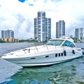 White yacht sailing past waterfront highrises in Miami