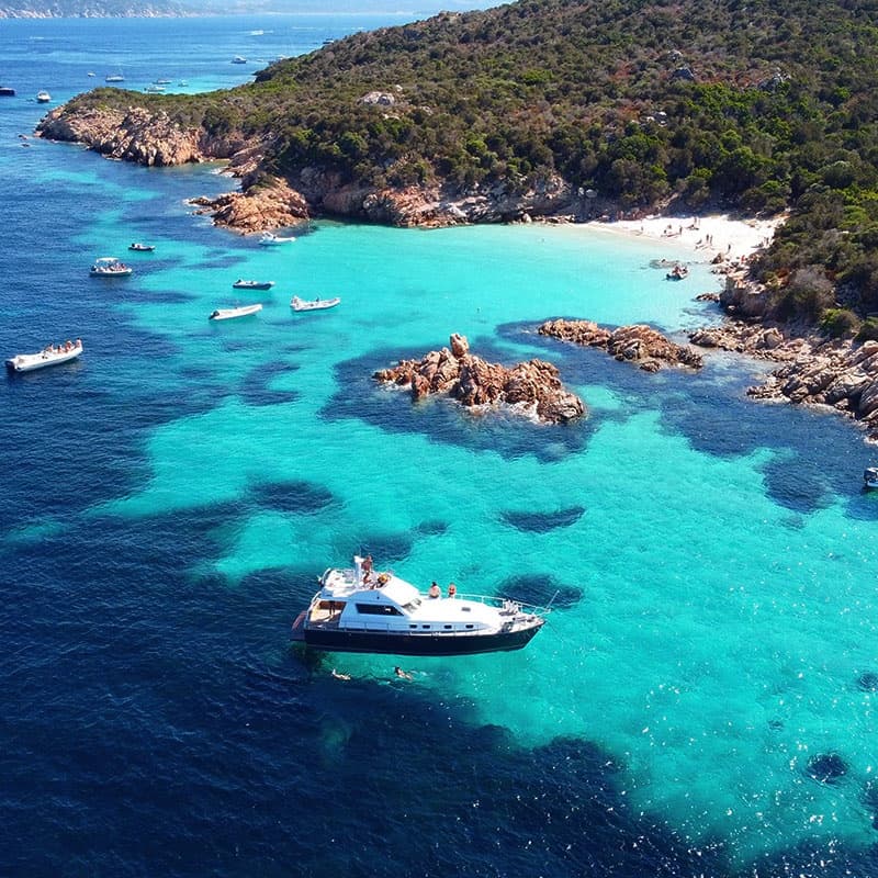 Luxury yacht moored near rocky turquoise cove for charter