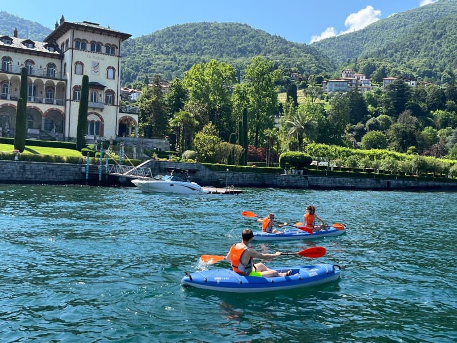 Family kayaking near lakeside villas on Lake Como summer outing