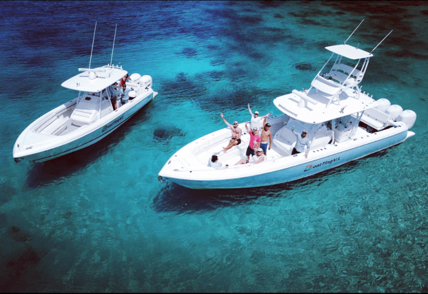 Two sportboats cruising turquoise Caribbean waters near shore