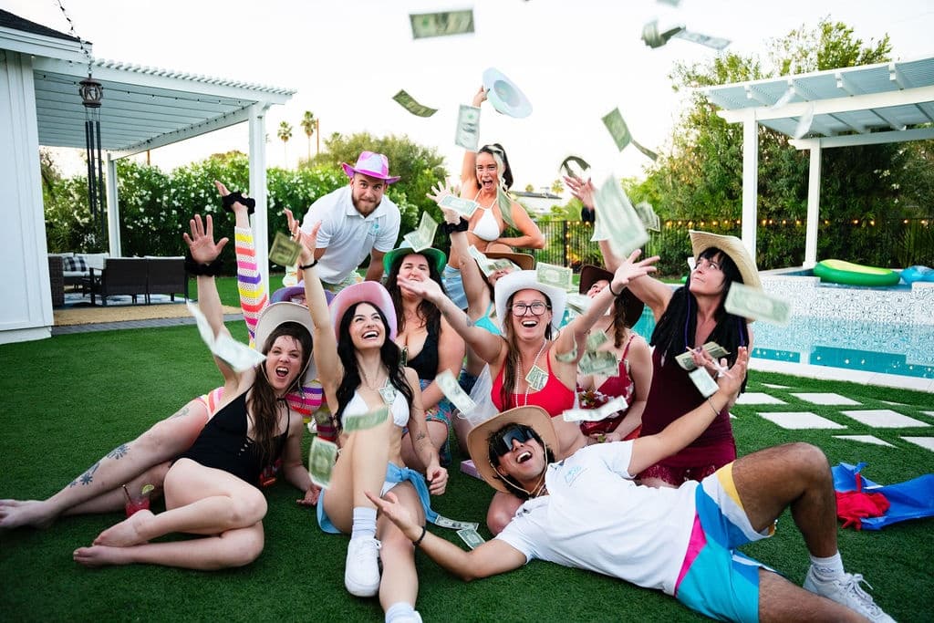 Lawn pool party group celebrating and tossing confetti outdoors