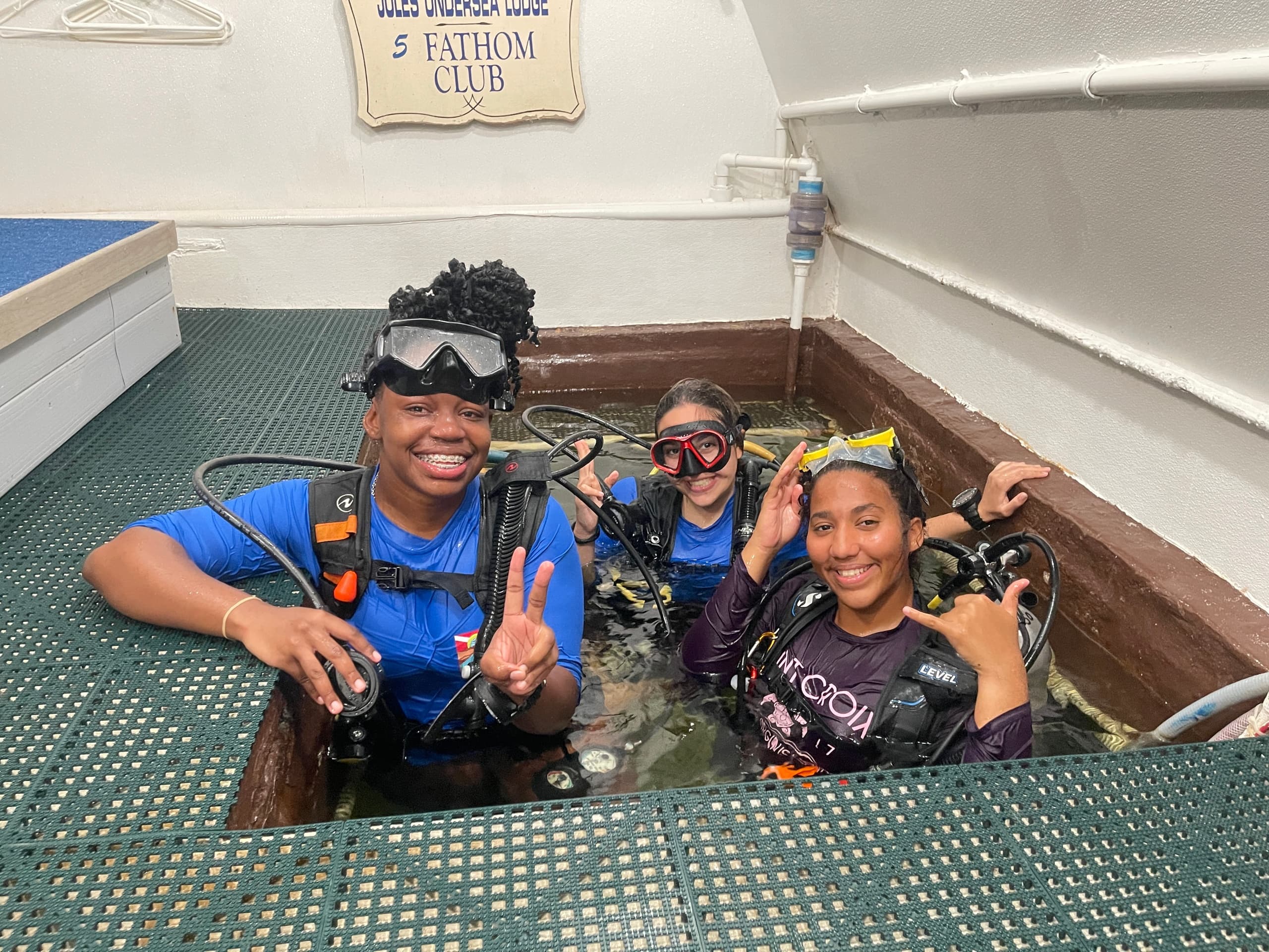 Students learning scuba skills on boat deck pool during dive training